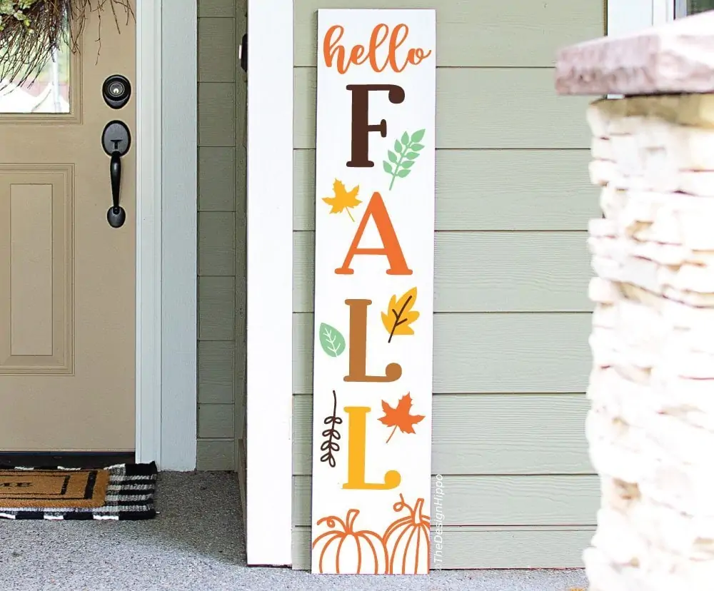 tall white porch sign that says hello fall with autumn leaves and pumpkins