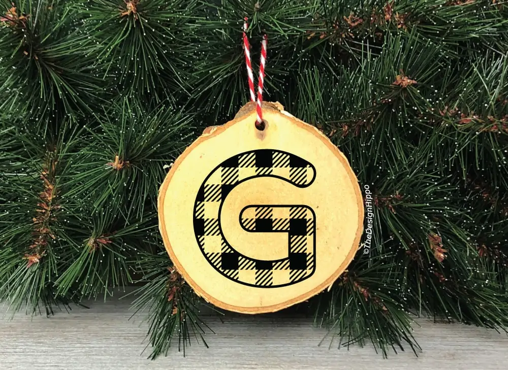 plaid patterned alphabet letter "G" on a wooden ornament hanging to a Christmas tree