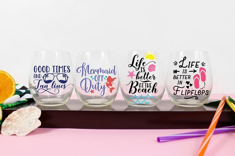 set of four colorful wine glasses with beach quotes made with cricut to sell for summer