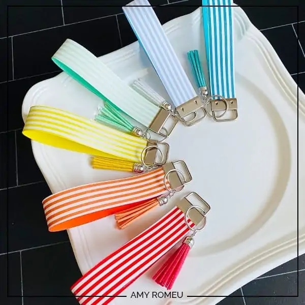 display of five colorful key fob keychains made with Cricut machine on a white plate
