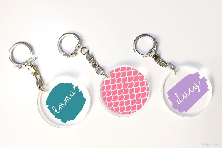 display of three acrylic keychains with free SVG designs made with Cricut