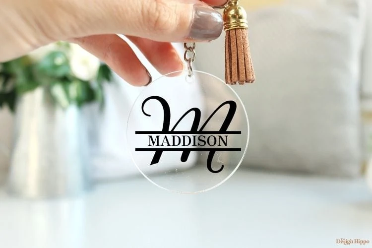 personalized monogram acrylic keychain with a tassel held by a women
