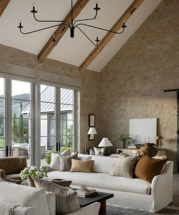 Black modern chandelier against wooden ceiling beams in contemporary living room