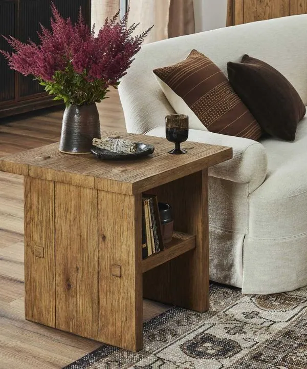 Rustic wooden side table with dark ceramic vase and wispy floral arrangement