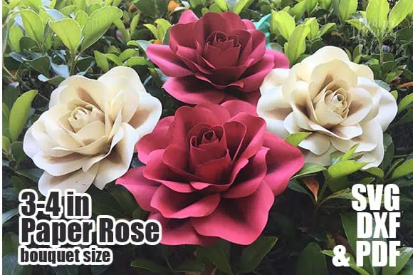 bouquet of cream and deep pink paper roses with green leaves