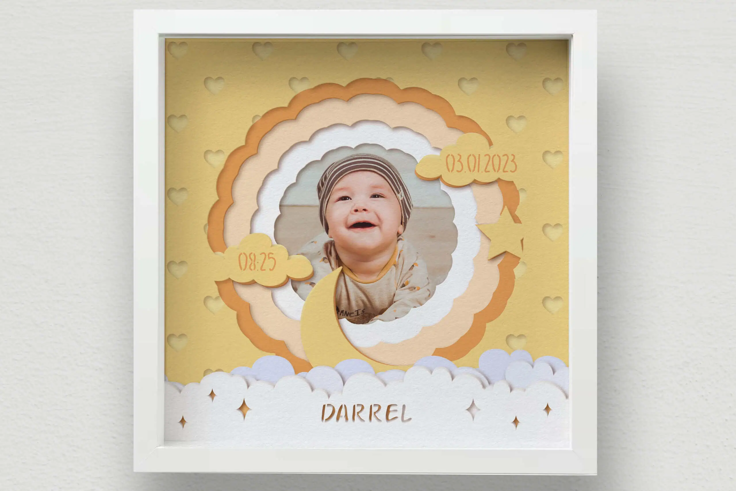 layered peach and cream shadow box frame around a baby photo with the name Darrel, a date and clouds