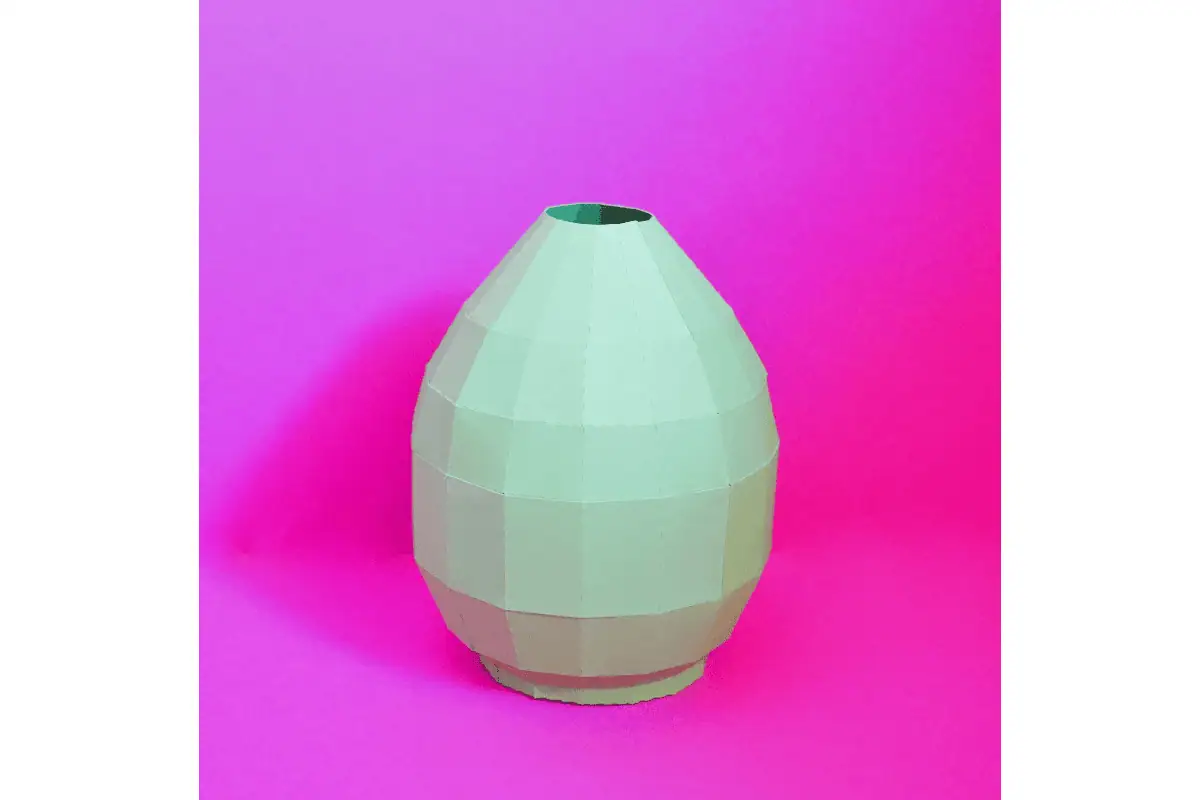mint green faceted paper vase on a pink background