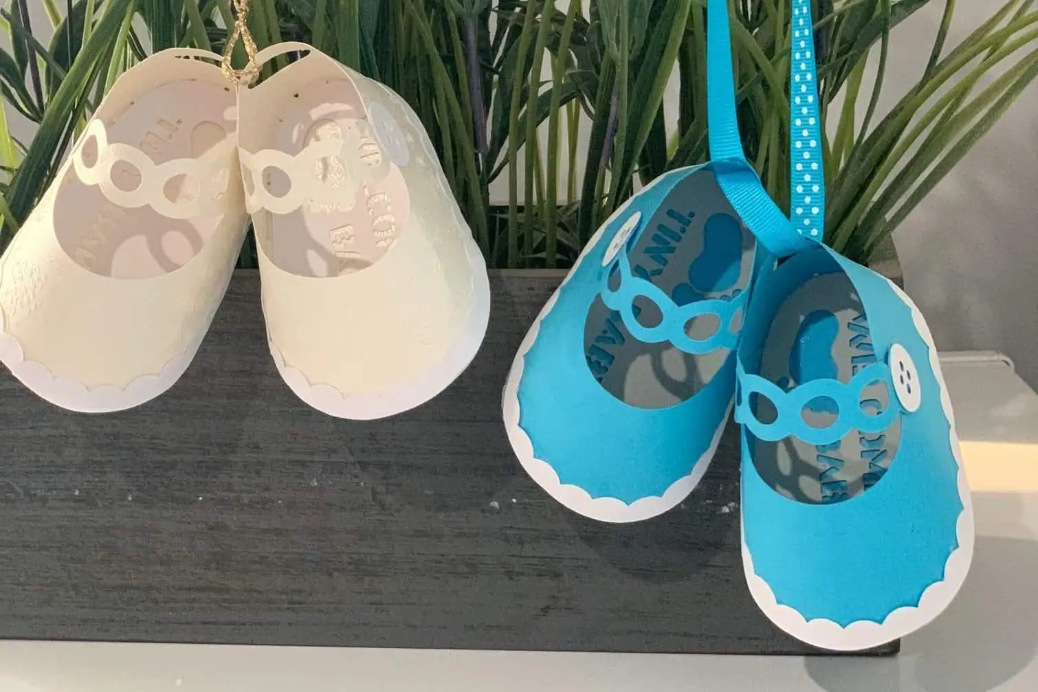 pair of cream and blue paper baby shoes with ribbon laces