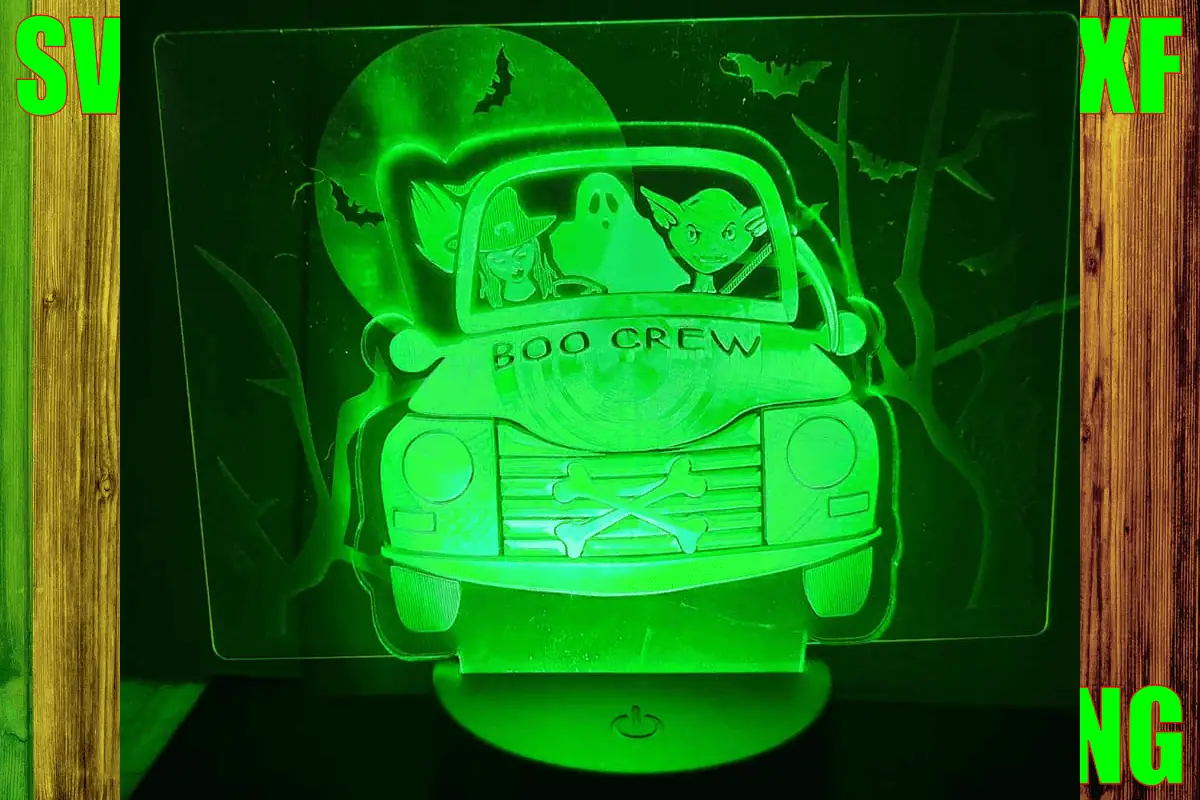engraved acrylic lamp of a truck carrying ghosts that says boo crew, glowing green