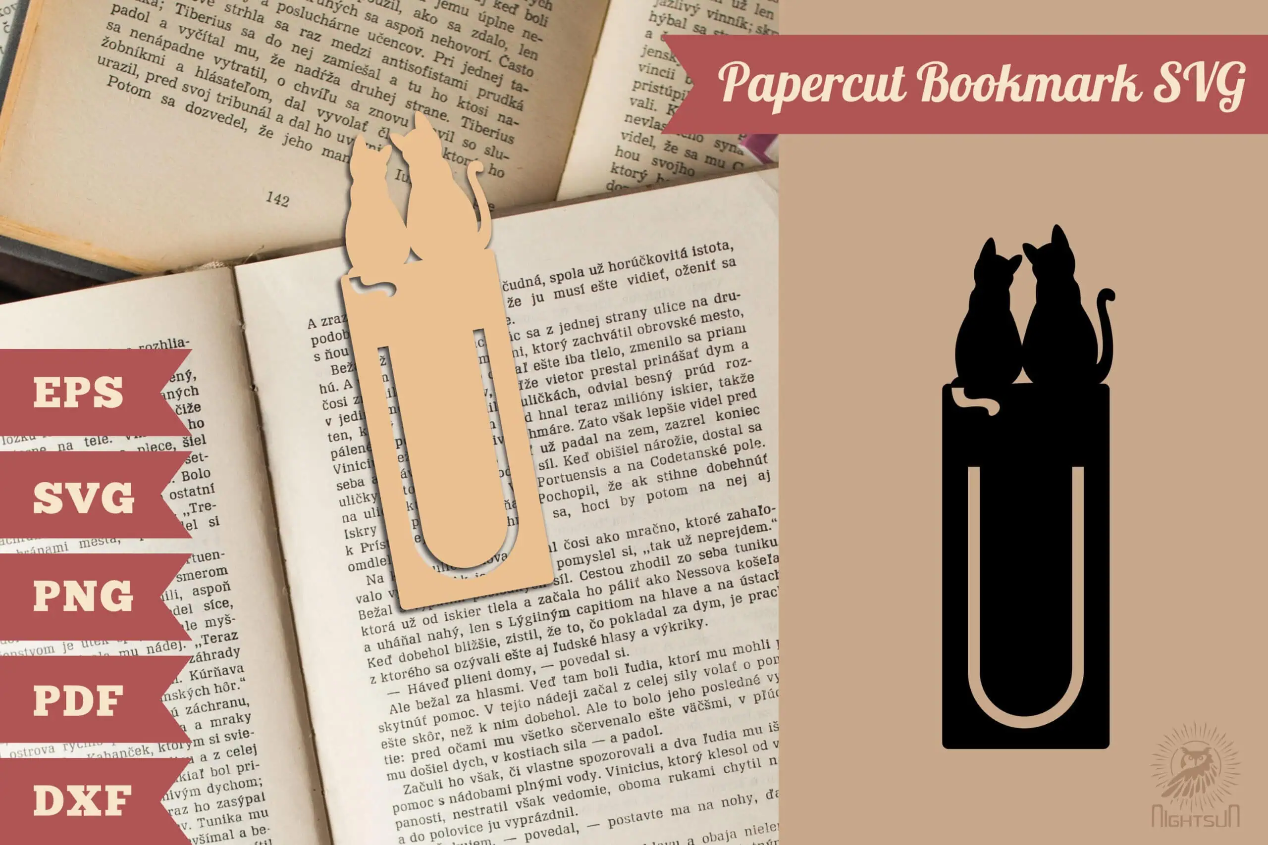 paper clip bookmark with two cats sitting on top clipped to the page of a book