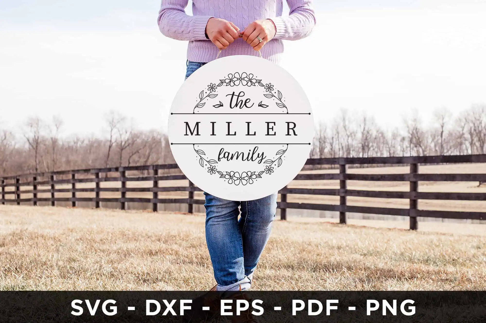 woman holding a round white sign that says the Miller family with a leafy wreath