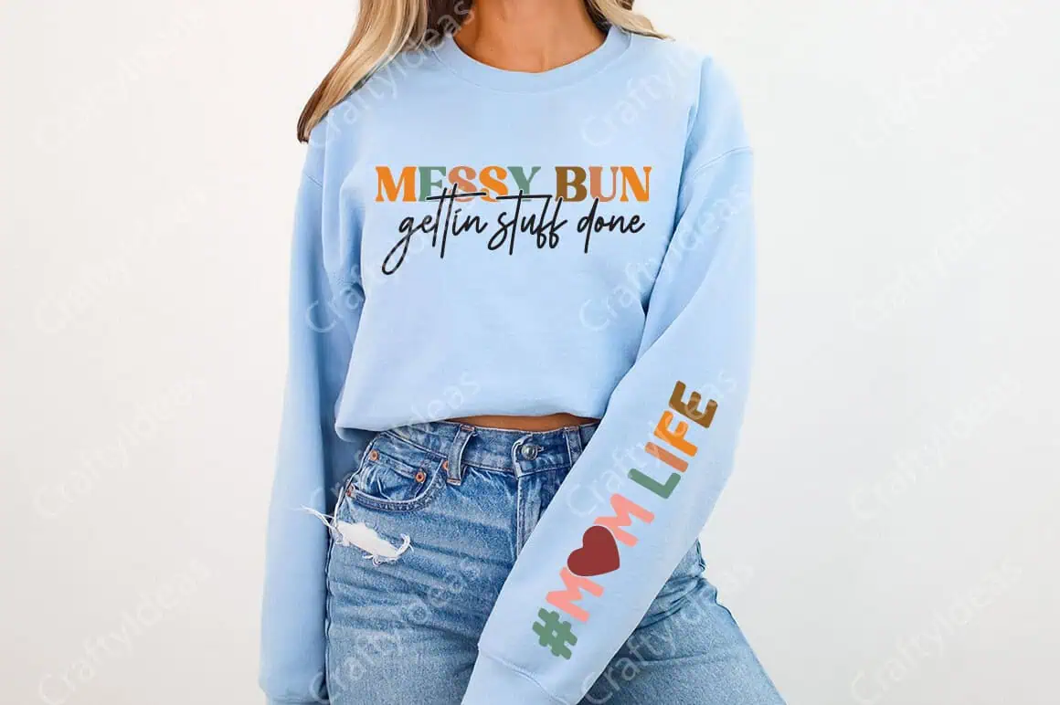 light blue sweatshirt that says messy bun gettin stuff done with a mom life design down the sleeve