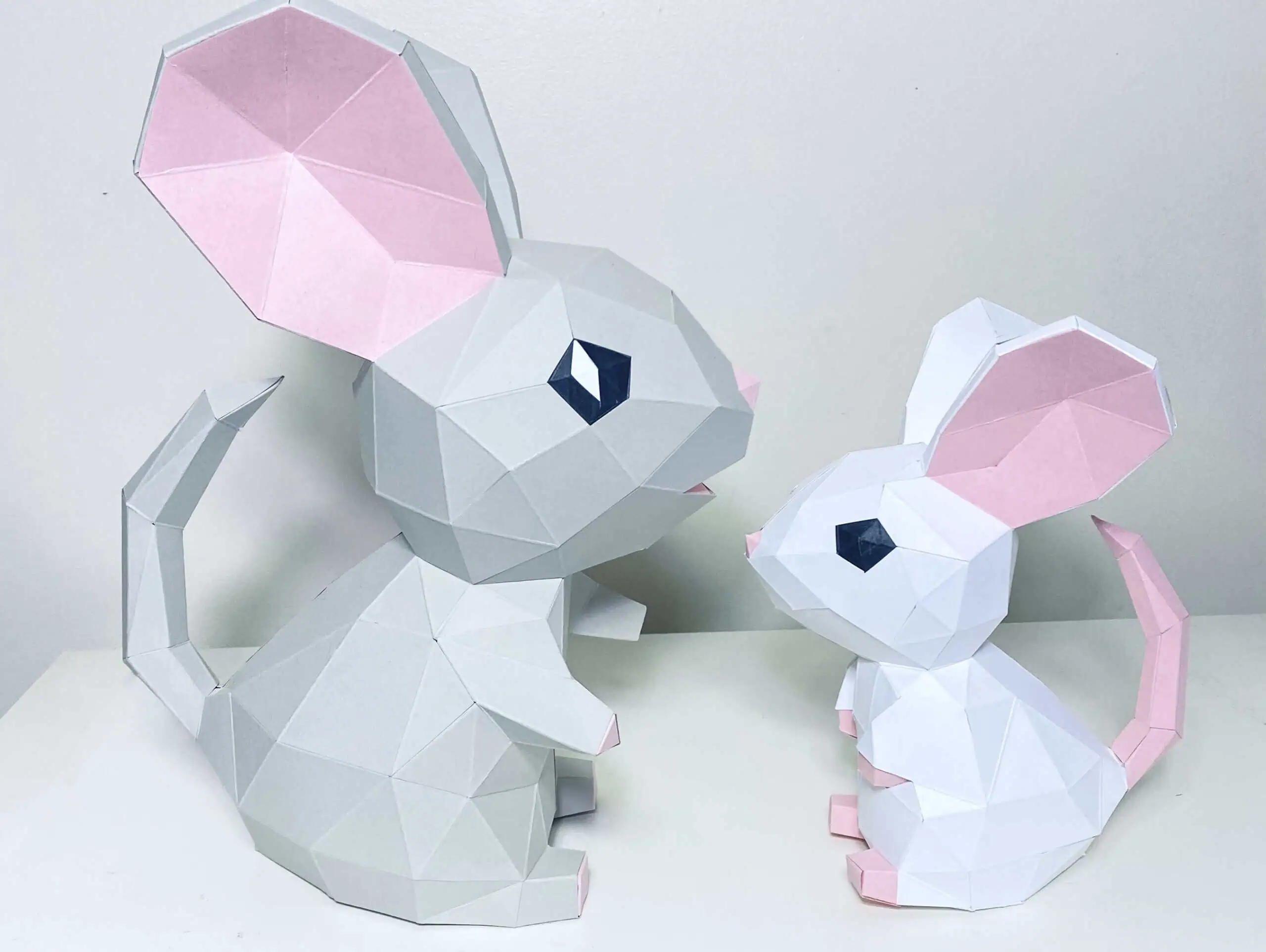gray and white low poly paper mice with pink ears, a mama mouse and a baby mouse