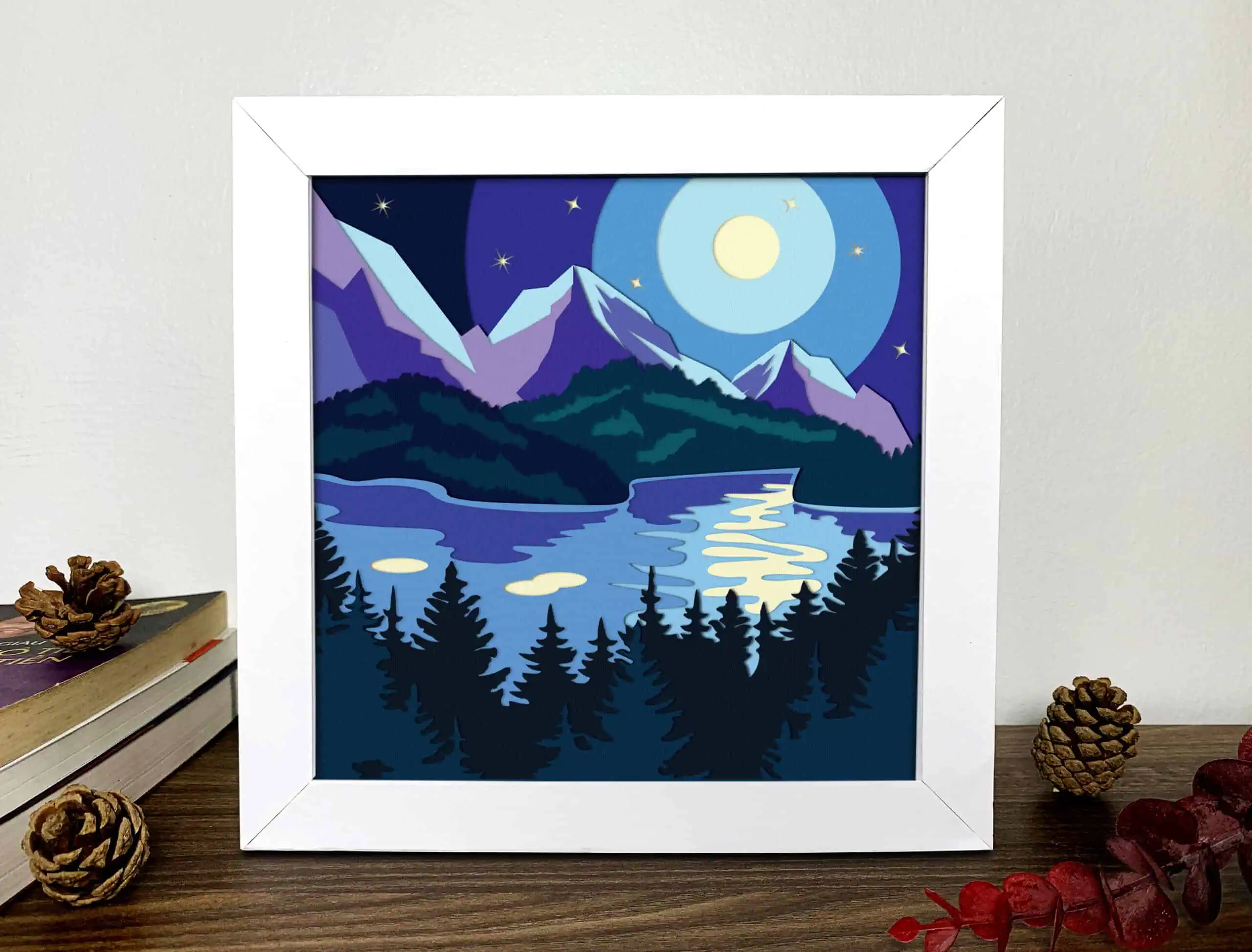 layered shadow box of a moonlit lake with purple mountains and dark pine trees