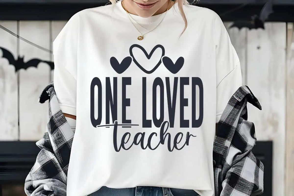 white t-shirt that says one loved teacher with three small hearts