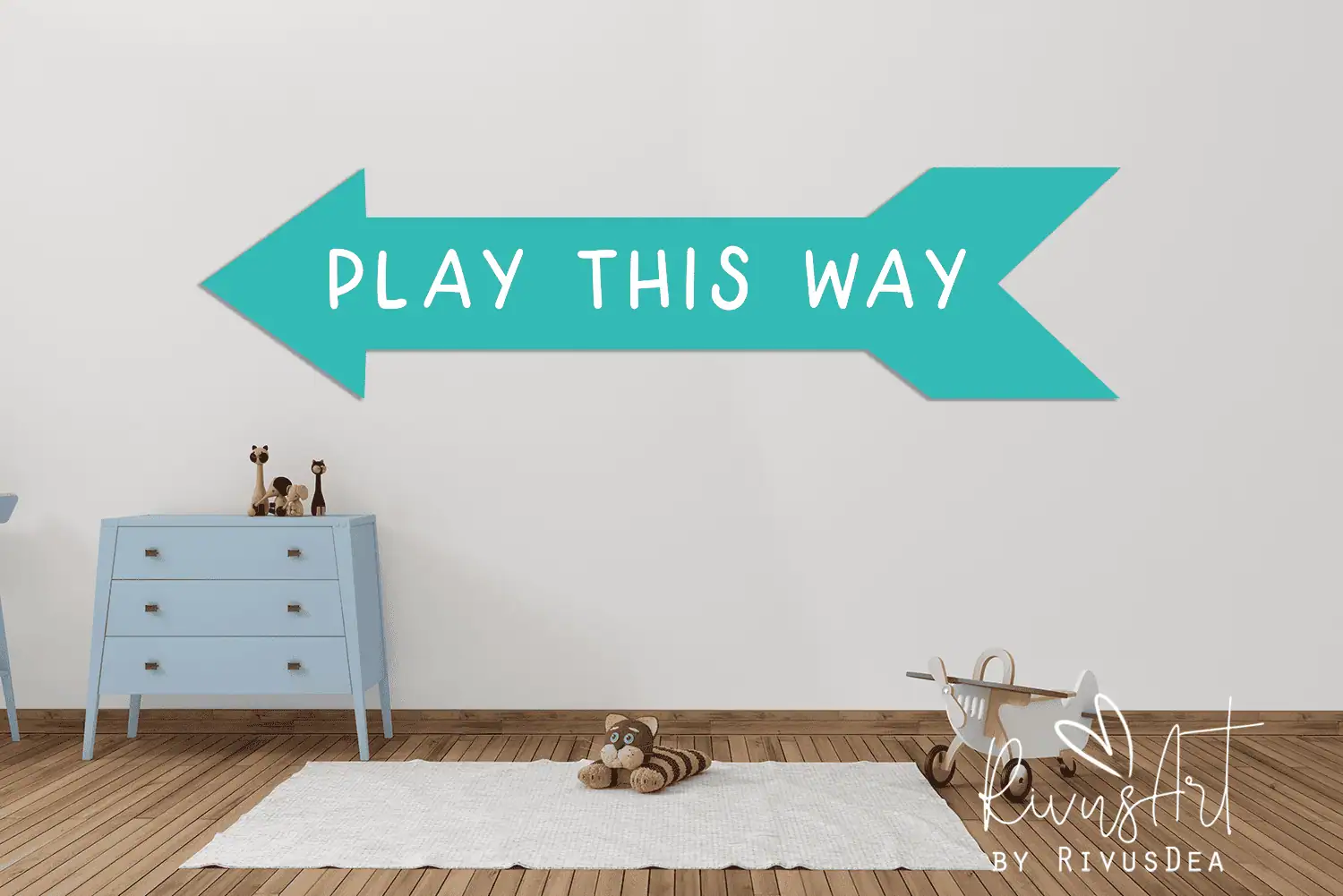 teal arrow wall decal that says play this way above a small blue dresser