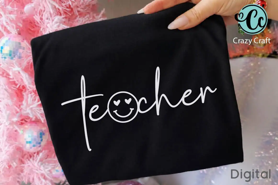 black t-shirt with teacher in white script and a smiley face in the letter a