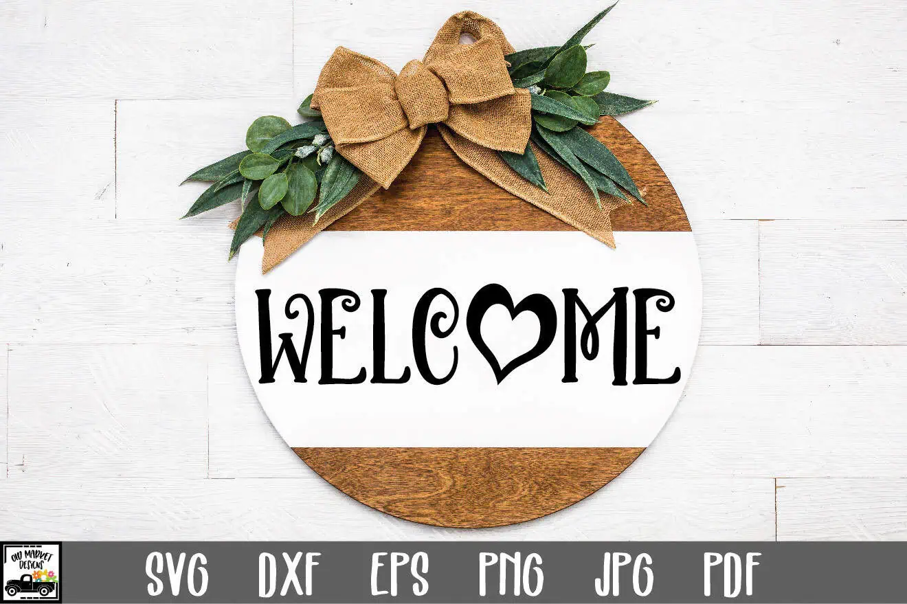 round white and brown wood welcome sign with a heart in the O, a tan bow and greenery