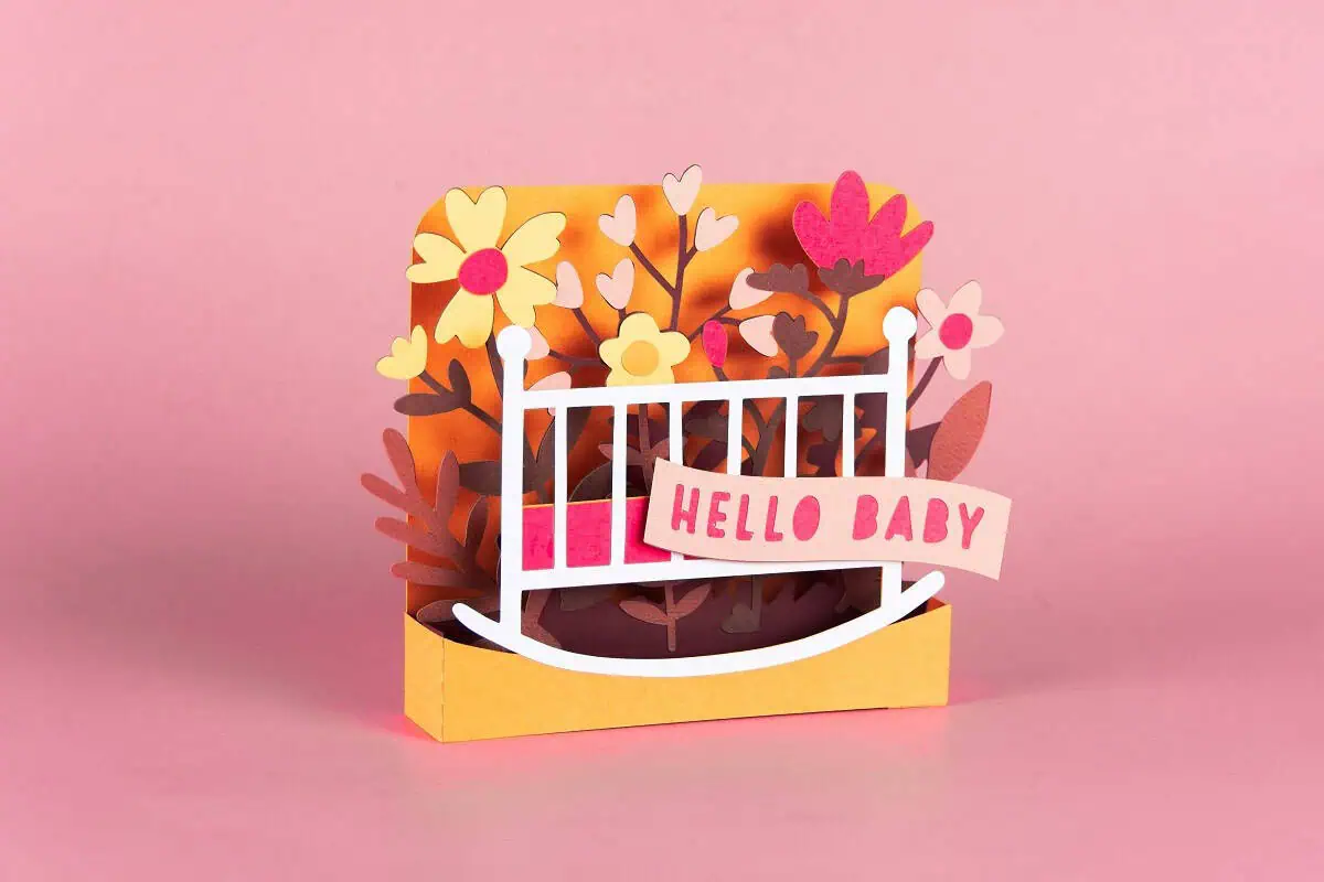 pop-up box card with a white crib and a hello baby banner surrounded by colorful paper flowers